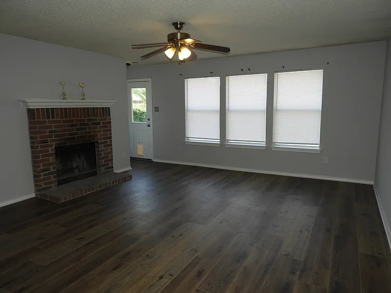 Living room with fireplace and ceiling fan.