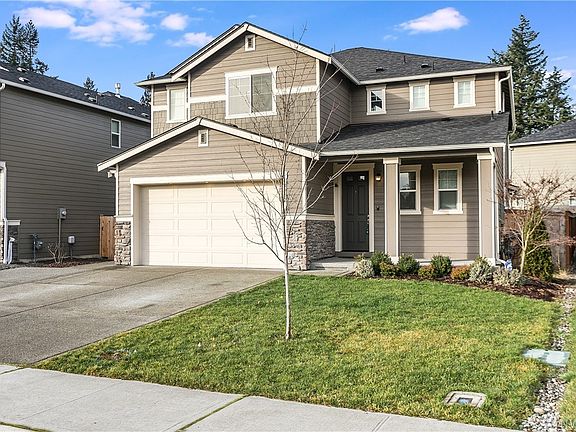 Front view of the main entrance with inviting covered porch and plenty of room for outdoor seating.