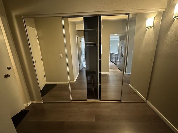 Mirrored entry closet reflecting the galley kitchen