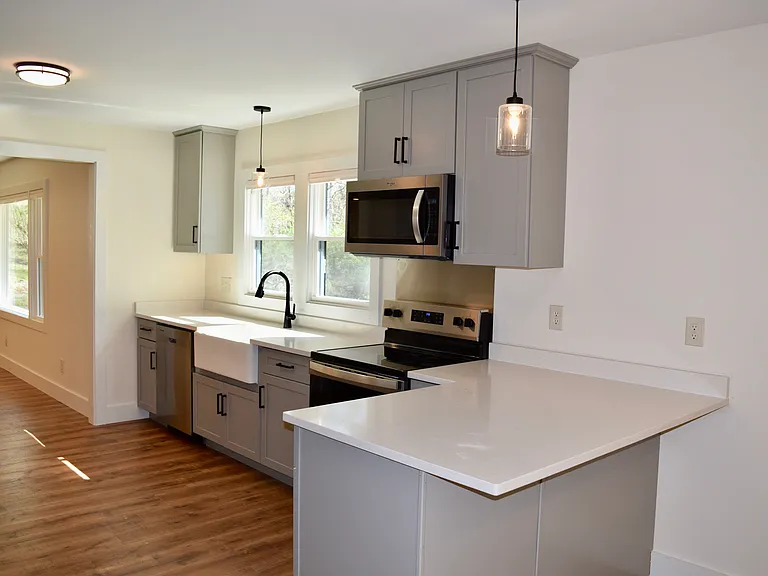 dishwasher, disposal, porcelain enameled farm sink, quartz countertops