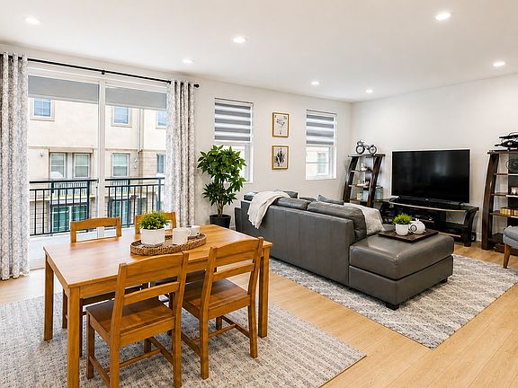 Open-concept living area featuring a modern sofa, smart TV, and custom wood wall paneling for a designer touch.