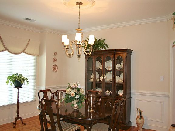 Formal dining room has crown molding and hardwood floors.