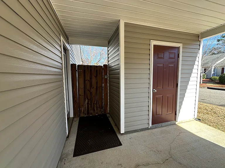 covered storage closet at end of carport and gate to the backyard