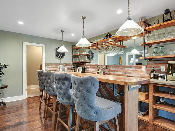 One of a kind custom bar, could also be used as a coffee or wine bar. Custom floating shelves, space for a mini-fridge under the counter also complete with running water.