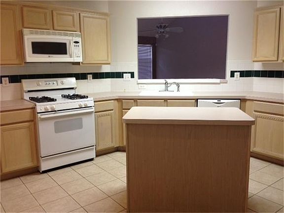 large kitchen with island and open to den with abundance of cabinets &counter space