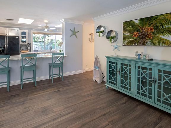 As you enter the home, the open, spacious feel greets you with warm wood floors and teal colored accents and furniture for a true Florida experience.