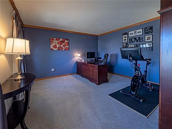 The family room boasts bright windows, plush carpet and crown molding.