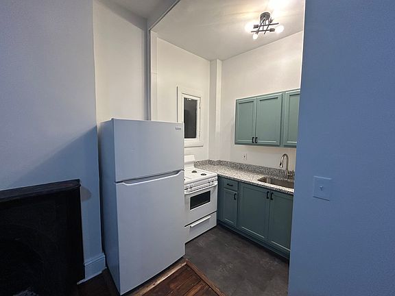 Bright, clean kitchen with brand new cabinets, granite counter, sink, and lighting.