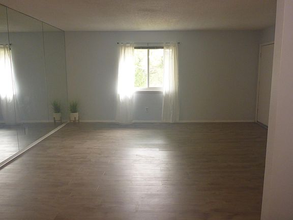 View of living room including window and walk with large mirror.