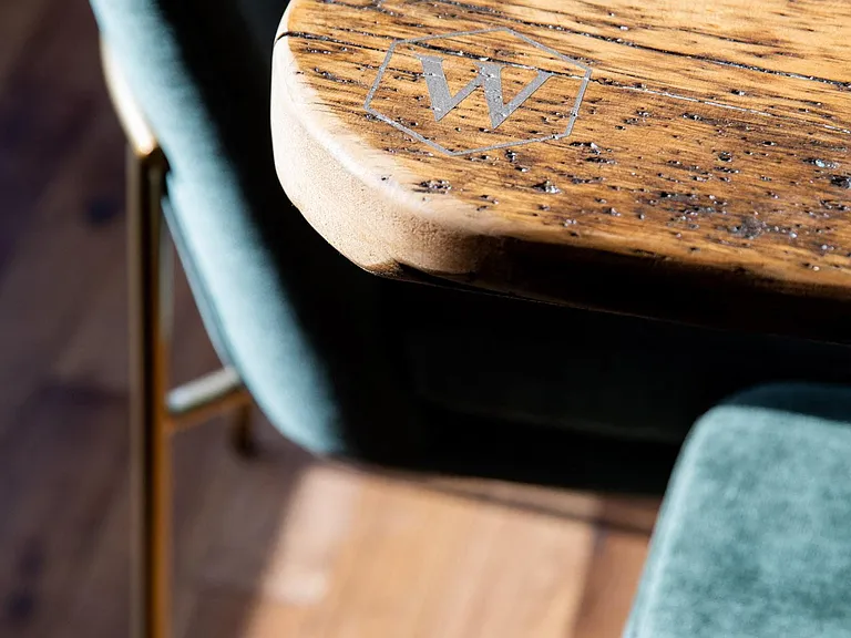 Custom table engraved with The Whitley logo.