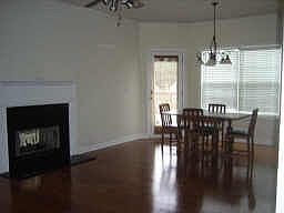 Keeping room with hardwood floors and a double sided fireplace.