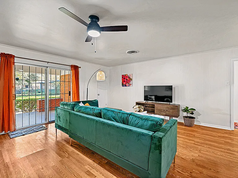 Bright living room with ample seating, Smart TV, and direct access to covered patio.