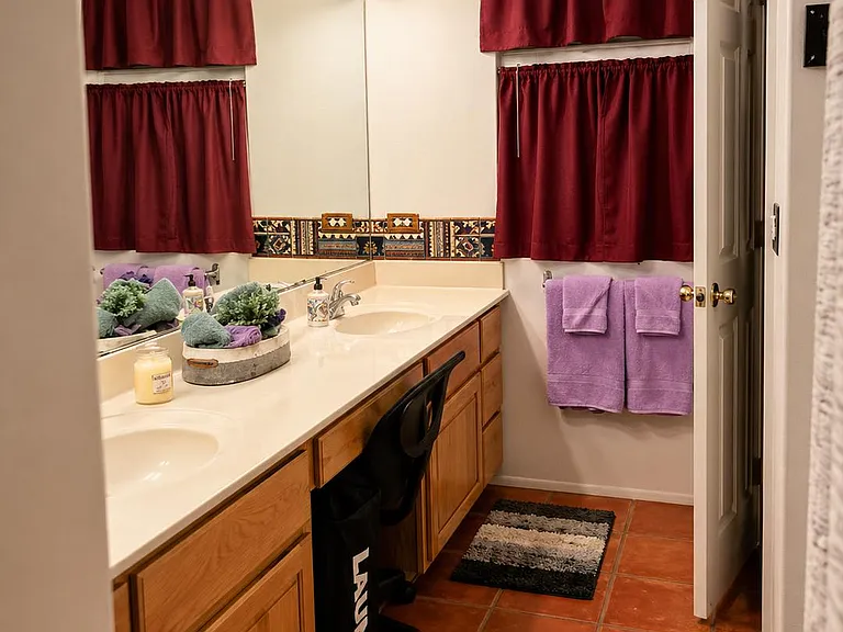 Spacious bathroom vanity with dual sinks, ample cabinet storage, and a large mirror for easy daily routines.