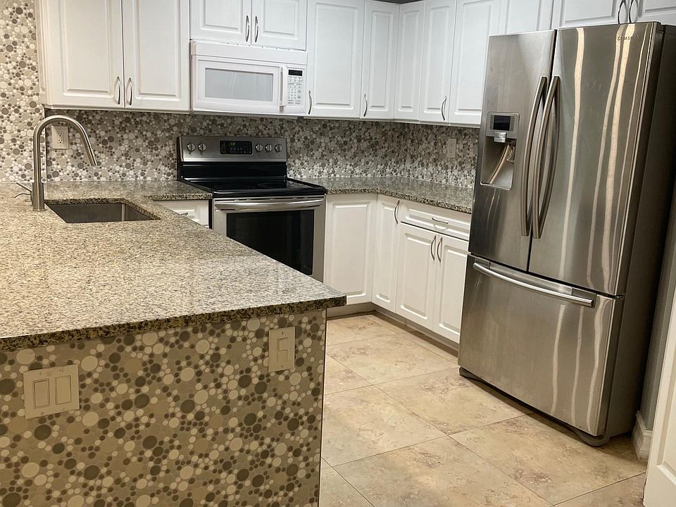 Kitchen with spacious cabinets, granite countertop, stainless steel fridge with lots of storage. Range, microwave, dishwasher and deep sink. 
Large counter-top