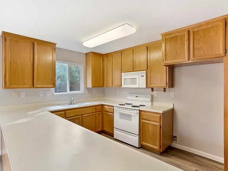The view into the kitchen, stove, microwave, & space for fridge.