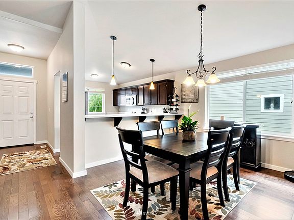 Hardwood floors throughout, from the entrance, into the kitchen and in the dining room. Notice the long breakfast bar!