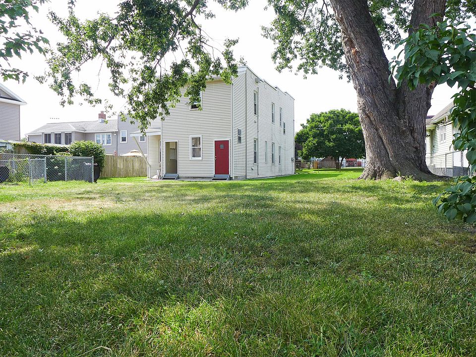 Huge fenced yard w/ tree for shade. Driveway is left of phot