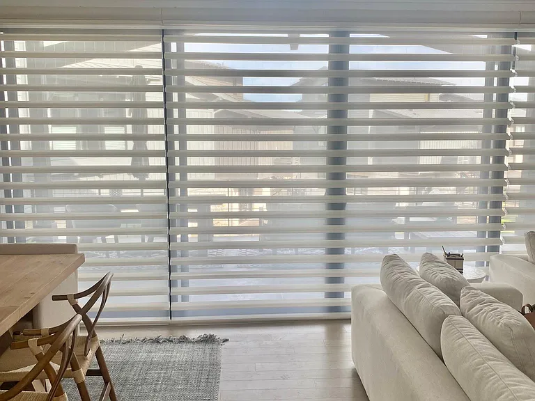 Large sliding door with custom automated window treatments throughout.