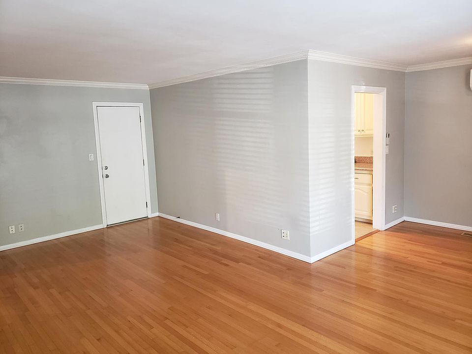 View upon entering living room, looking towards backdoor leading to courtyard (left) and the galley kitchen entrance through dinging room to the right.
