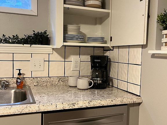 Many small appliances, dishes, and a brand new dishwasher with a third rack.