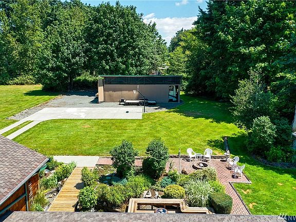 View of back yard, RV & boat shop. Firepit, basketball/ sports court, 2nd driveway for easy access to RV's, boats and trailers.
