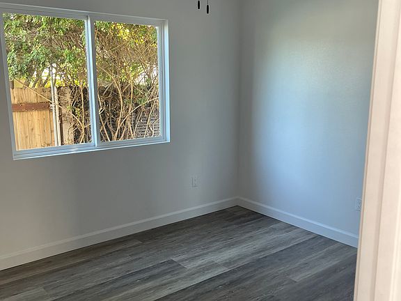 Back bedroom with fan and closet, barn wood laminate flooring.