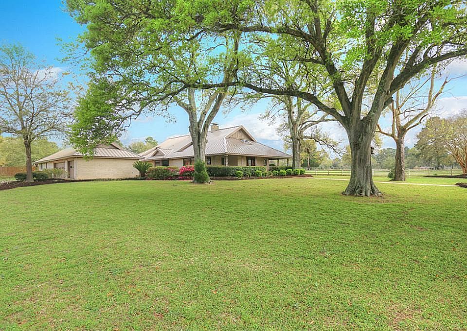 Located on a rise in Tomball sits this custom home and 9.396 picturesque acres.