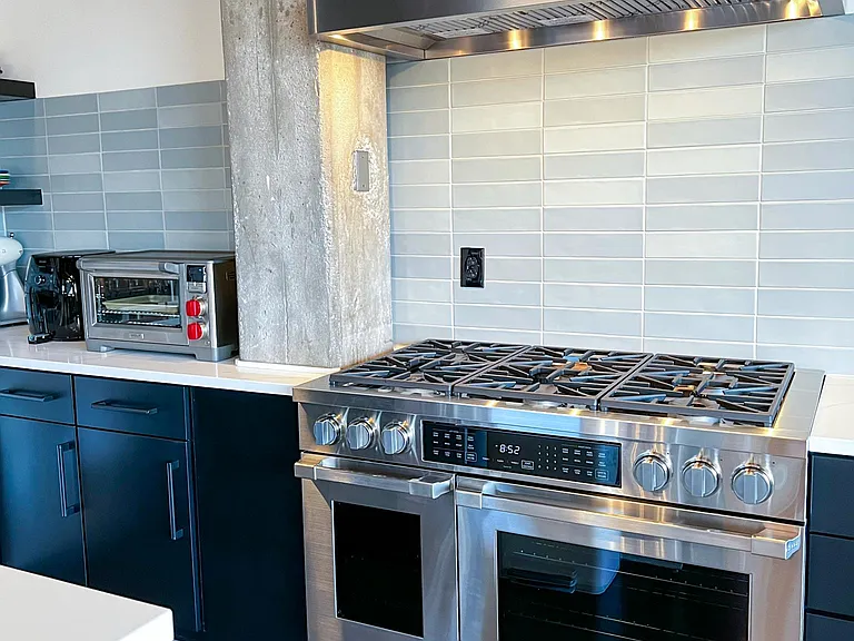 48" Dual fuel range with gas burners and (2) electric ovens.