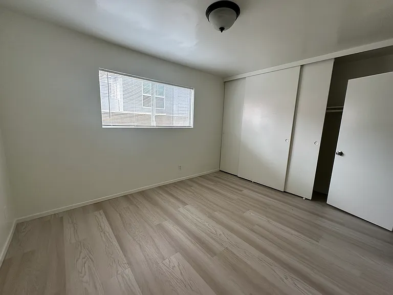 Good size bedroom with laminate flooring off the garage with its own bath
