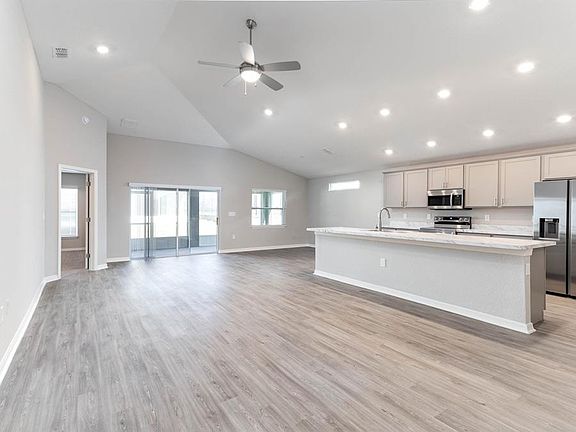 Enjoy a summy, open living area with vinyl plank flooring - New home for sale in Davenport, FL