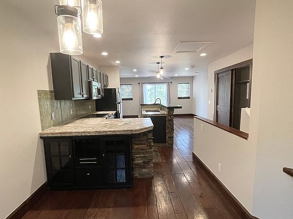from dining room looking through kitchen to living and patio leading to deck. Coffee bar with built in storage.