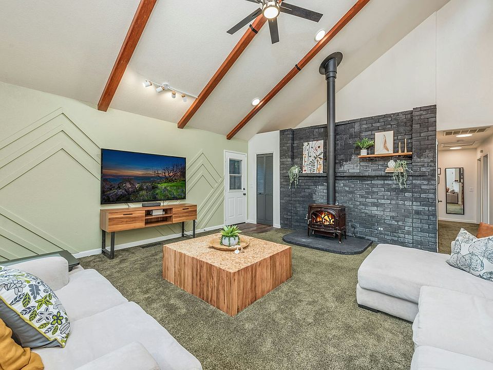 Family Room with wood stove and vaulted ceilings. 70" TV is included! Furniture is for illustrative purposes.
