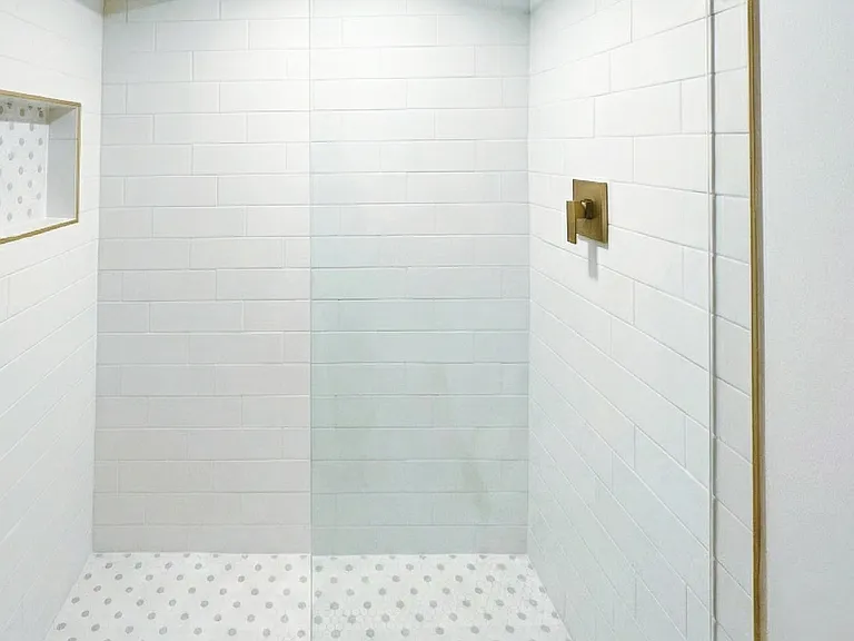 Walk-in shower with modern tile, glass enclosure, and fresh updated finishes.