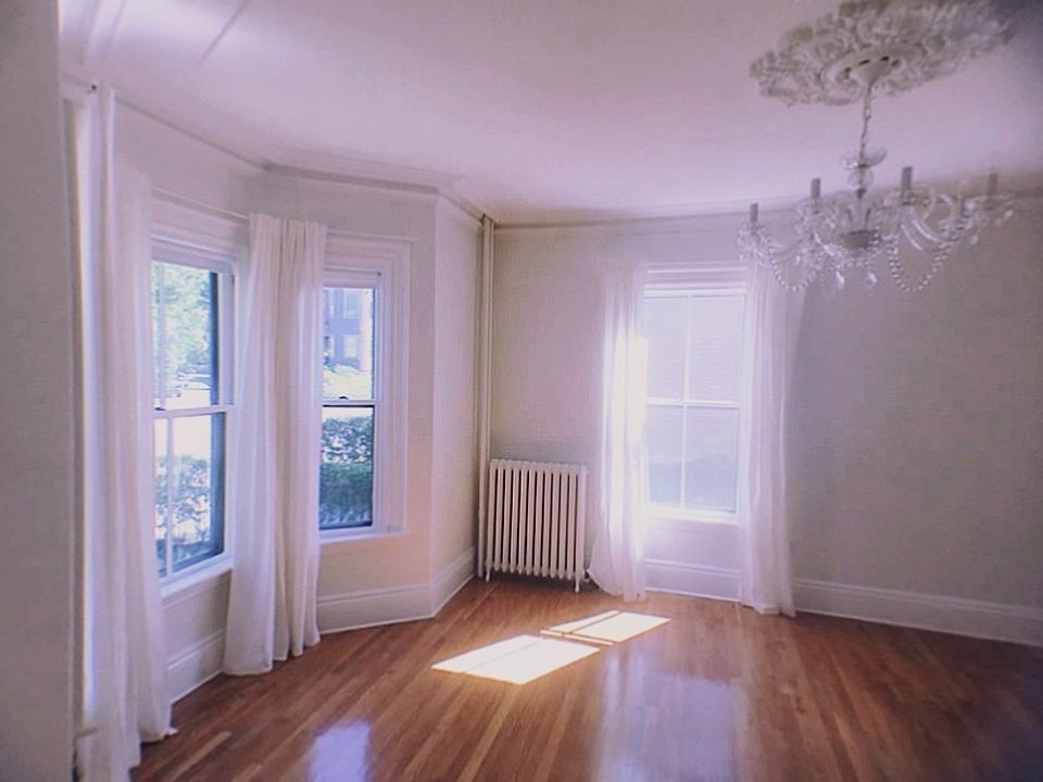 The front room has old world character with four large windows and high ceilings, original plaster crown moulding and ceiling medallion, and the old marble mantel piece. Before move in, the walls will be repainted will be repainted Ben Moore Simply White.