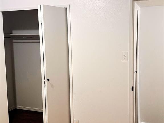 Unfurnished bedroom with dark wood finished floors and a closet