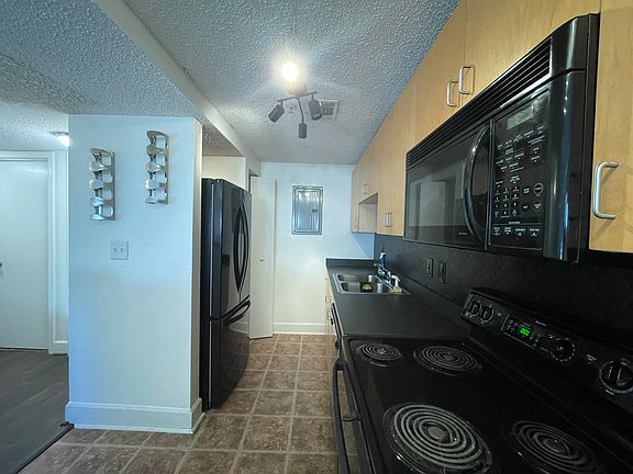 Kitchen with microwave, dishwasher, electric oven, full size refrigerator and pantry.