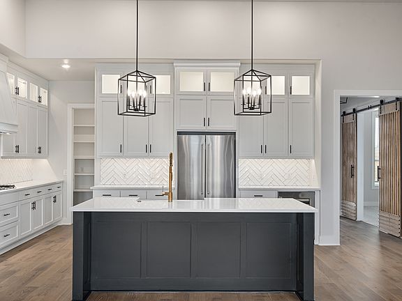 The kitchen of the Hefner has a large islands with quartz countertops.