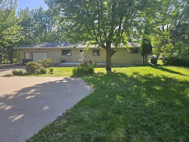 View from back; single car garage, large deck and patio. Large round about, in front of detached two car garage