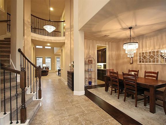 Pottery Barn fixtures paired with elegant design elements such as soaring ceilings, rich hardwoods and curving staircase and wrought iron balusters.