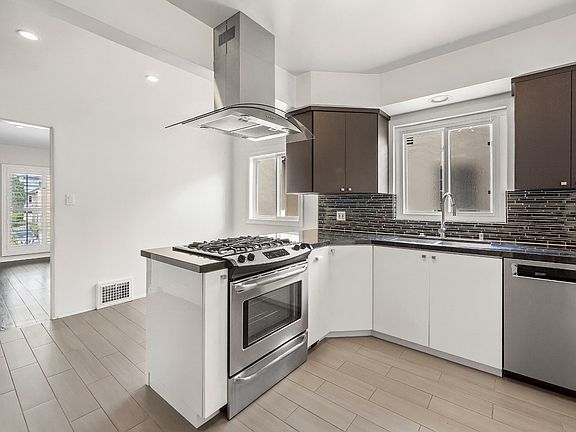 Kitchen view from fridge area with high-end dishwasher and double sink