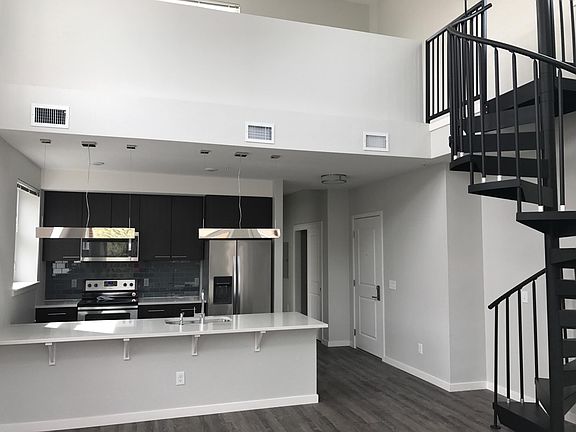 Open living spaces, spiral staircase up to loft which can serve as an office or 2nd bedroom