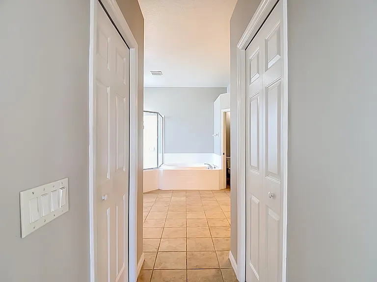 Hallway to primary bathroom. 2 walk-in closets.