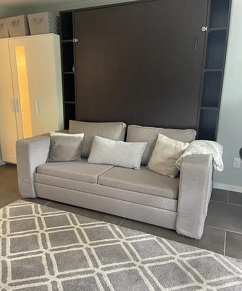 Murphy bed converts into a sofa when the queen bed is in the cabinet.