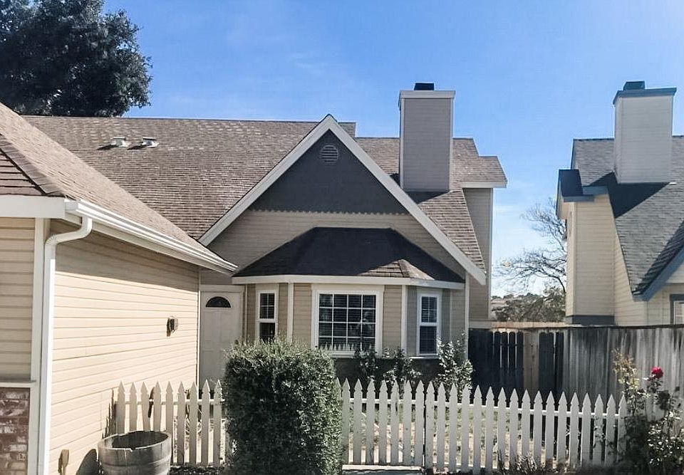 Duplex with small fenced lawn are in front and graveled backyard and detached 1-car garage