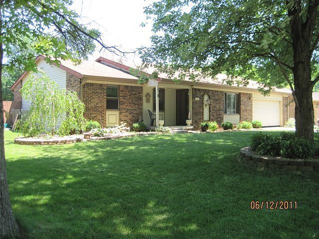 Exterior front with mature landscaping.