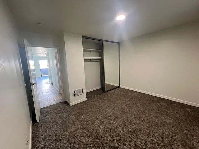 Large bedroom with large mirrored closet doors