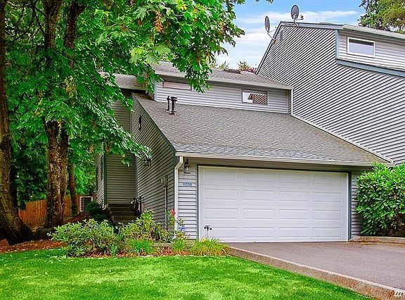 Large townhome with side-by-side 2 car garage and coveted full 2 car parking pad in front of garage. Garage has built-in cabinetry and storage in the rafters.