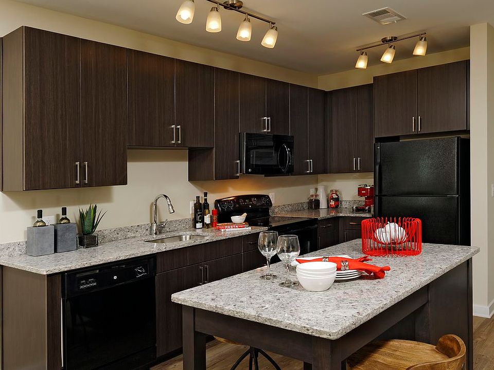 Contemporary Finish Package kitchen with espresso cabinetry, black appliances, kitchen island, granite countertops and hard surface plank flooring