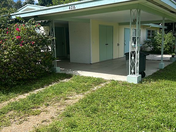 Carport with utility/storage room closet and side patio.