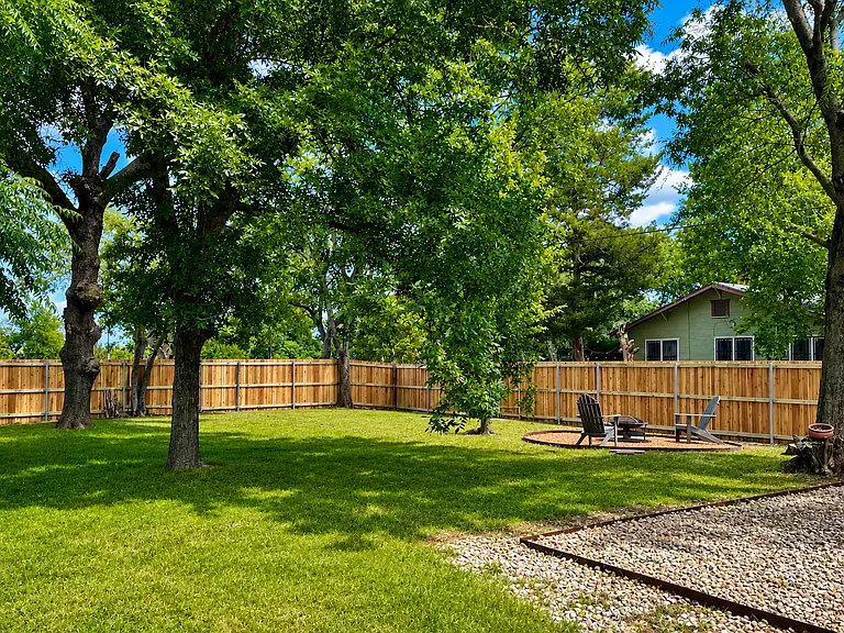 Massive, fully fenced backyard with a private patio, cozy fire pit, and plenty of room to relax, play, or enjoy time with your pet.